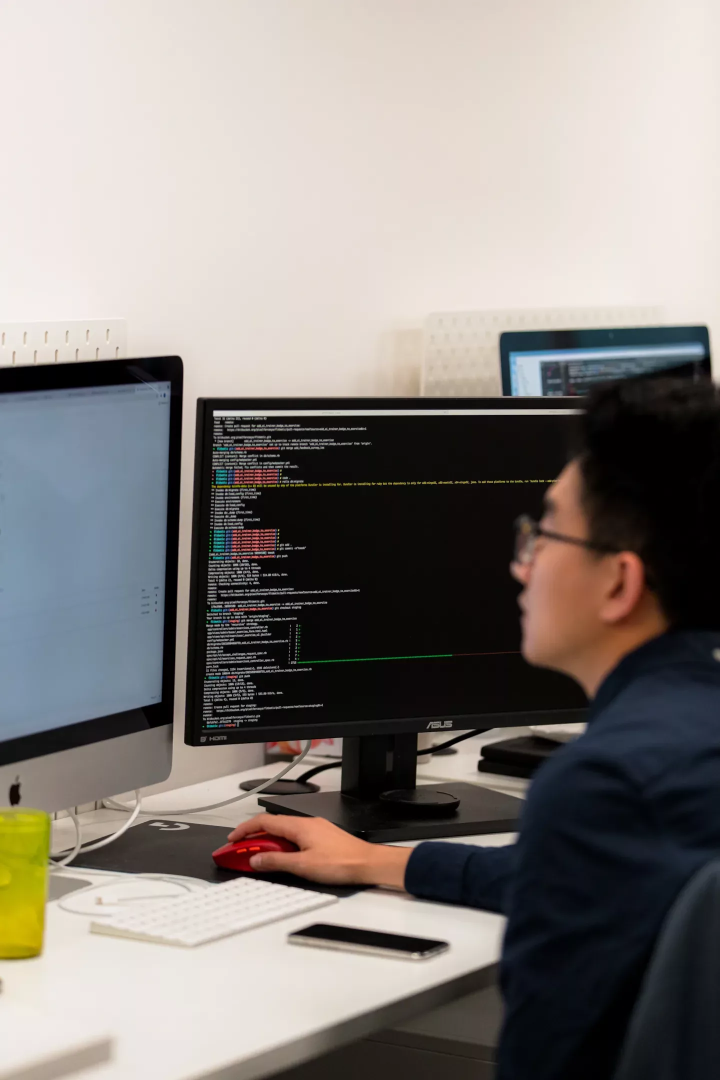 A PixelForce developer reading application code on a second monitor at a dual-screen desk