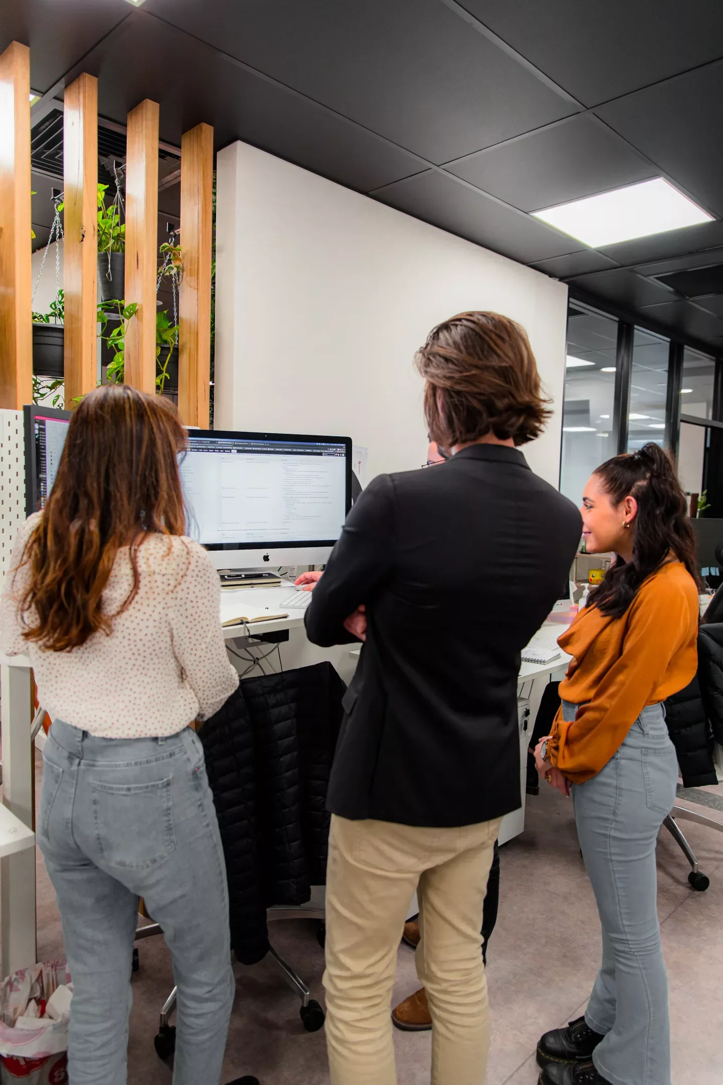 Three PixelForce team members reviewing a web application on a desktop monitor in the Kent Town studio